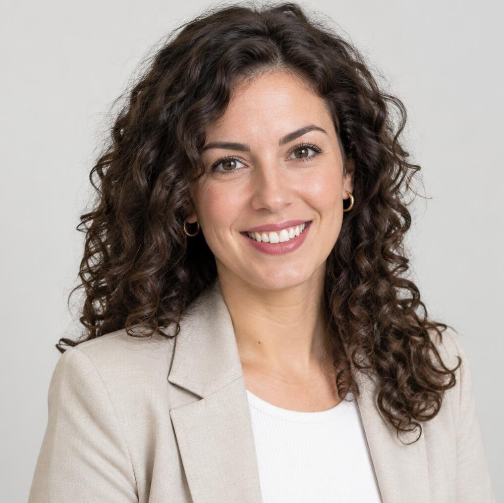 Studio portrait of a young woman with curly hair smiling